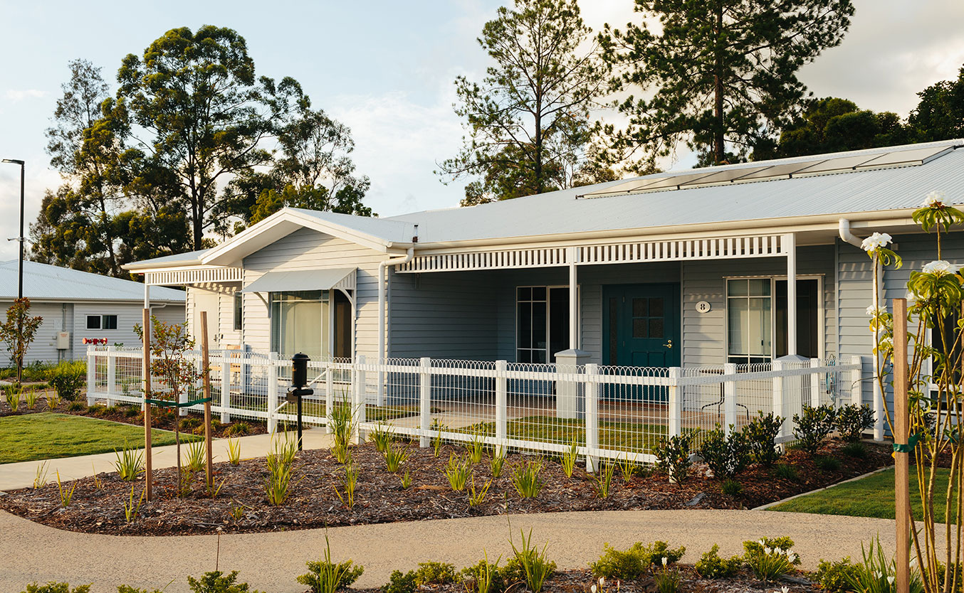 Home at New Direction Care with a porch and fence | Featured Image for the MICRO TOWN® Model Concept page of NewDirection Care.