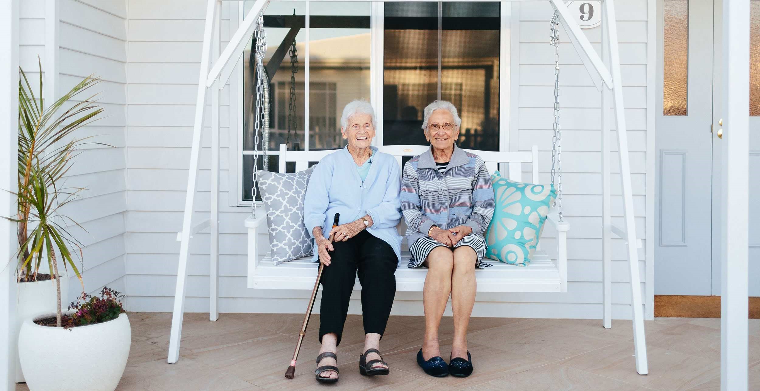 Elderly women sitting together on a swinging chair | Featured Image for the Disability Aged Care Page of NewDirection Care.