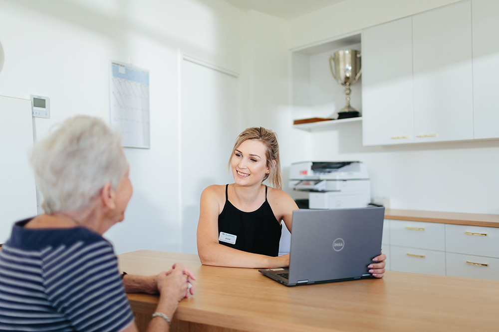 Support worker and resident having a conversation | Featured image for the Inclusive Care Page by NewDirection Care.