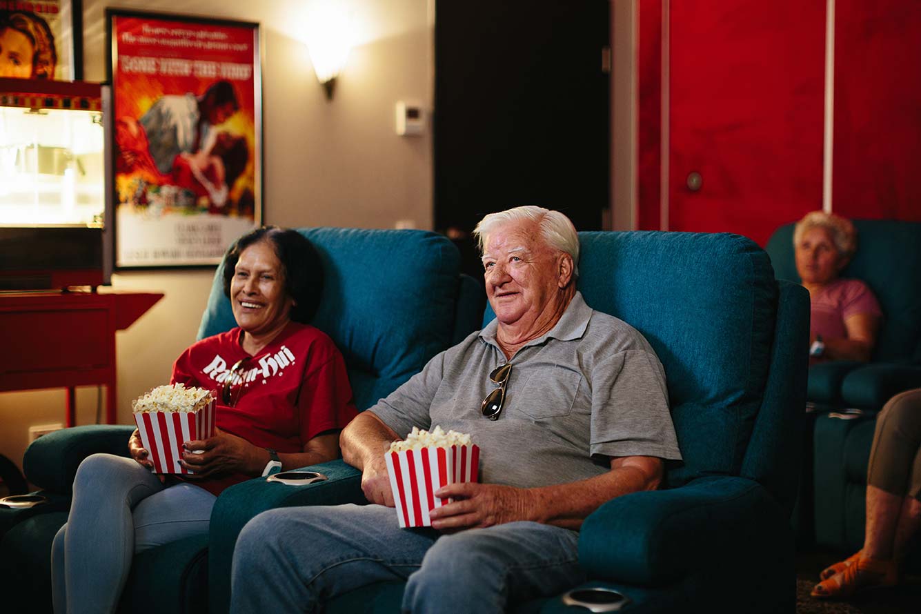 Old couple watching a movie | Featured image for the about us page of NewDirection Care